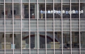 Staff stand in a meeting room at the Lehman Brothers offices in the financial district of Canary Wharf in London September 11, 2008. Lehman Brothers eventually filed for bankruptcy - the largest bankruptcy in U.S. history - and was delisted from the NYSE, and later liquidated.