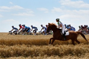 A woman on a horse runs alongside the peloton during stage five of the 2008 Tour de France from Cholet to Chateauroux on July 9, 2008 in Chateauroux, France. (Jasper Juinen/Getty Images)