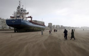 Locals and tourists walk around the Dutch ship Artemis which ran aground on the beach of les Sables d'Olonne, southern French Britanny, western France, March 10, 2008. The boat had been driven onto the coast by the wind blowing more than 130 km per hour. (REUTERS/Stephane Mahe)